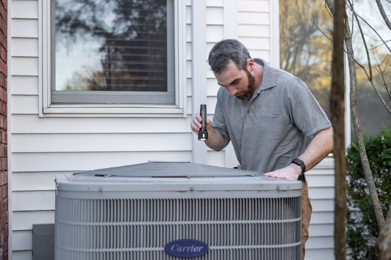 Crafting Captivating Headlines: Your awesome post title goes here A technician inspects an outdoor HVAC unit for maintenance.
